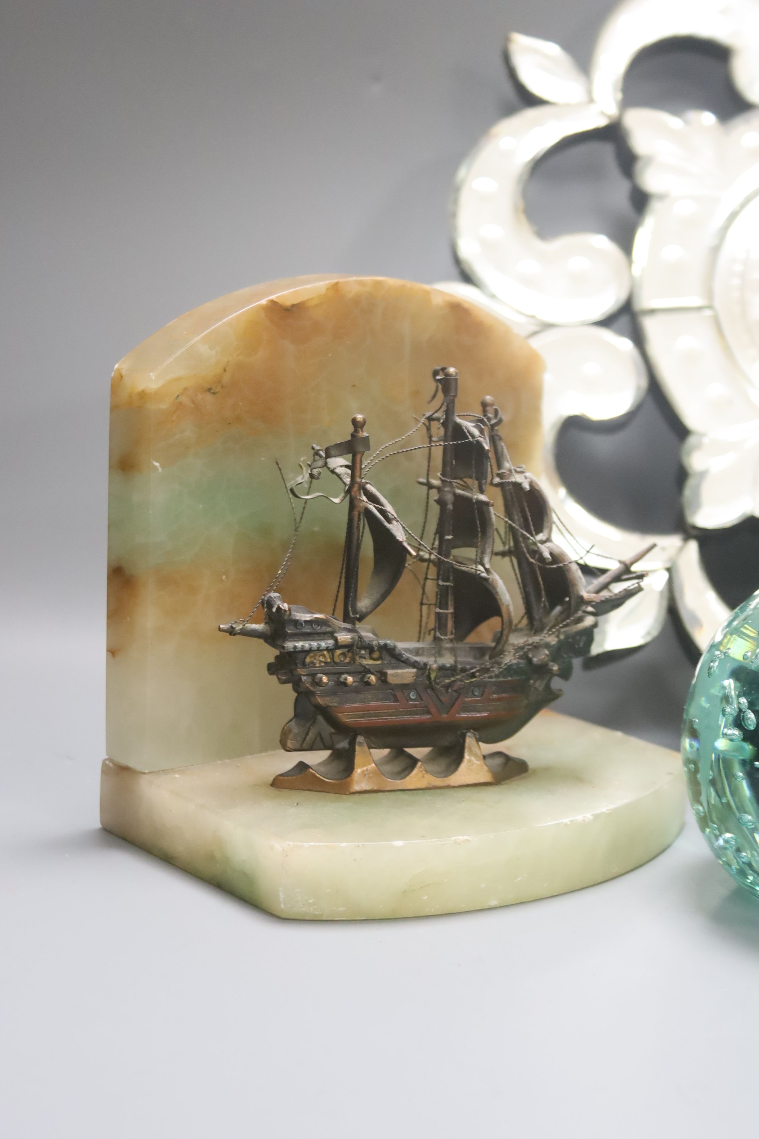 A small Venetian mirrored glass wall clock and a pair of green glass ‘candleholder’ dumps and a pair of ship bookends 33cm